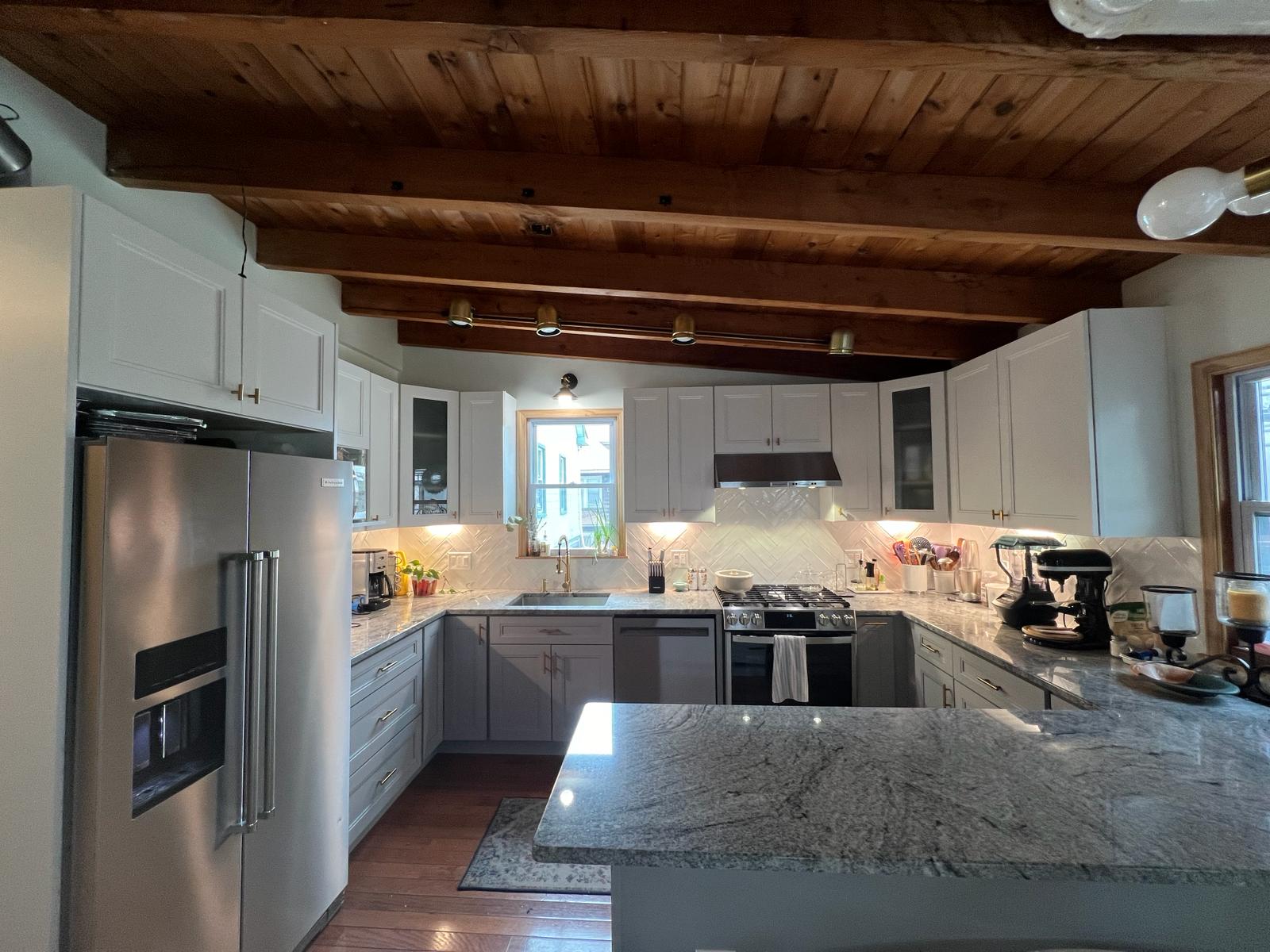 White shaker kitchen remodel with granite island and herringbone backsplash in Philadelphia