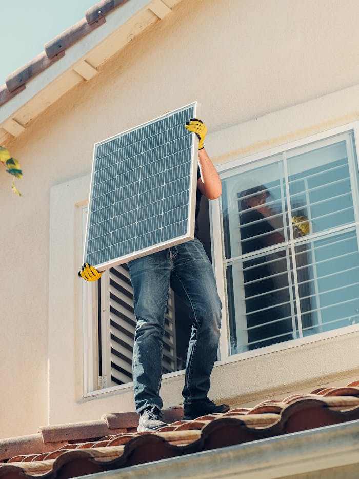 expertise-01 Technician carrying a solar panel on a rooftop for installation, promoting renewable energy.